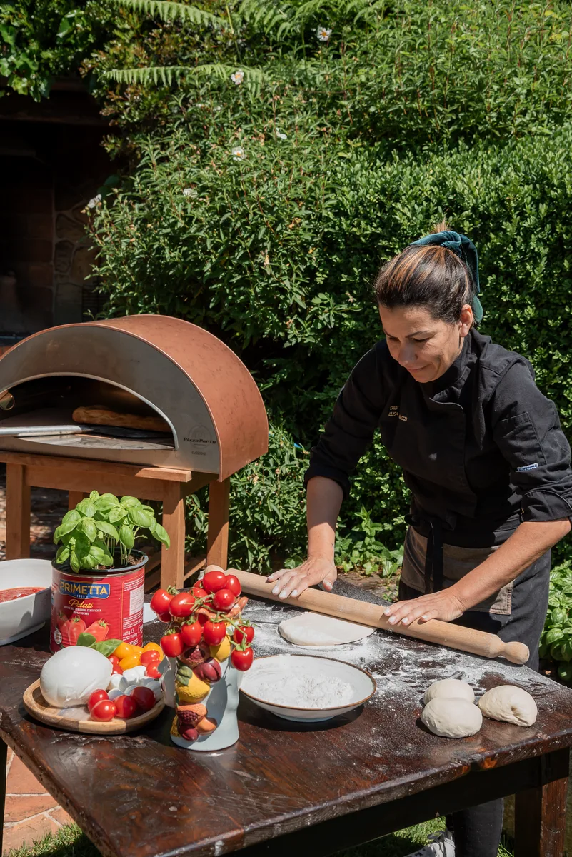 Chef Elisa preparing pizza in wood oven at Il Podere di Toscana Tuscany